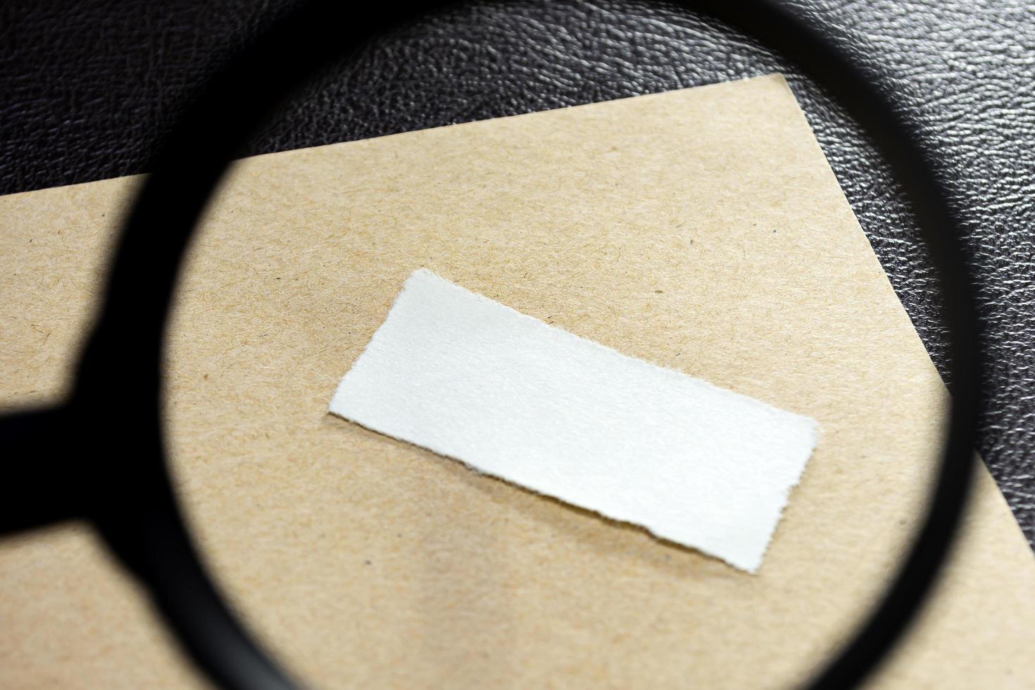 carta e busta su superficie di legno con lente d'ingrandimento. copia spazio. disteso foto