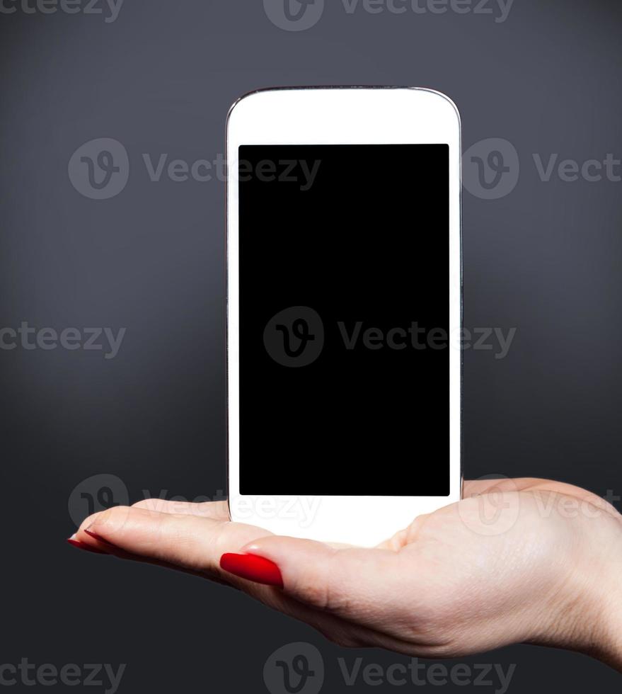 smartphone bianco su una mano femminile foto