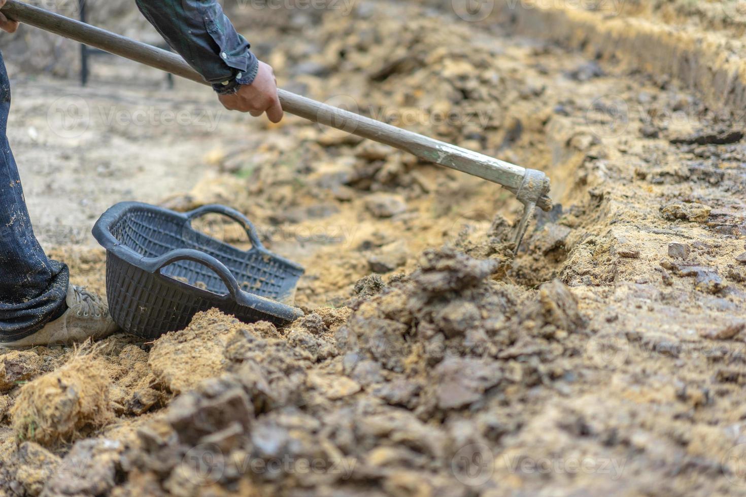 il giardiniere scava il terreno con la sua attrezzatura per il giardinaggio e prepara il terreno per la piantagione. foto