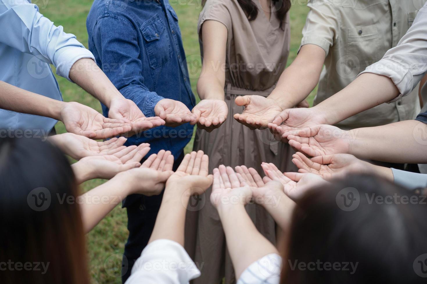 gruppo di persone asiatiche alza la mano destra e maneggia delicatamente per ottenere e condividere buone sensazioni insieme nell'allenamento del teambuilding. foto