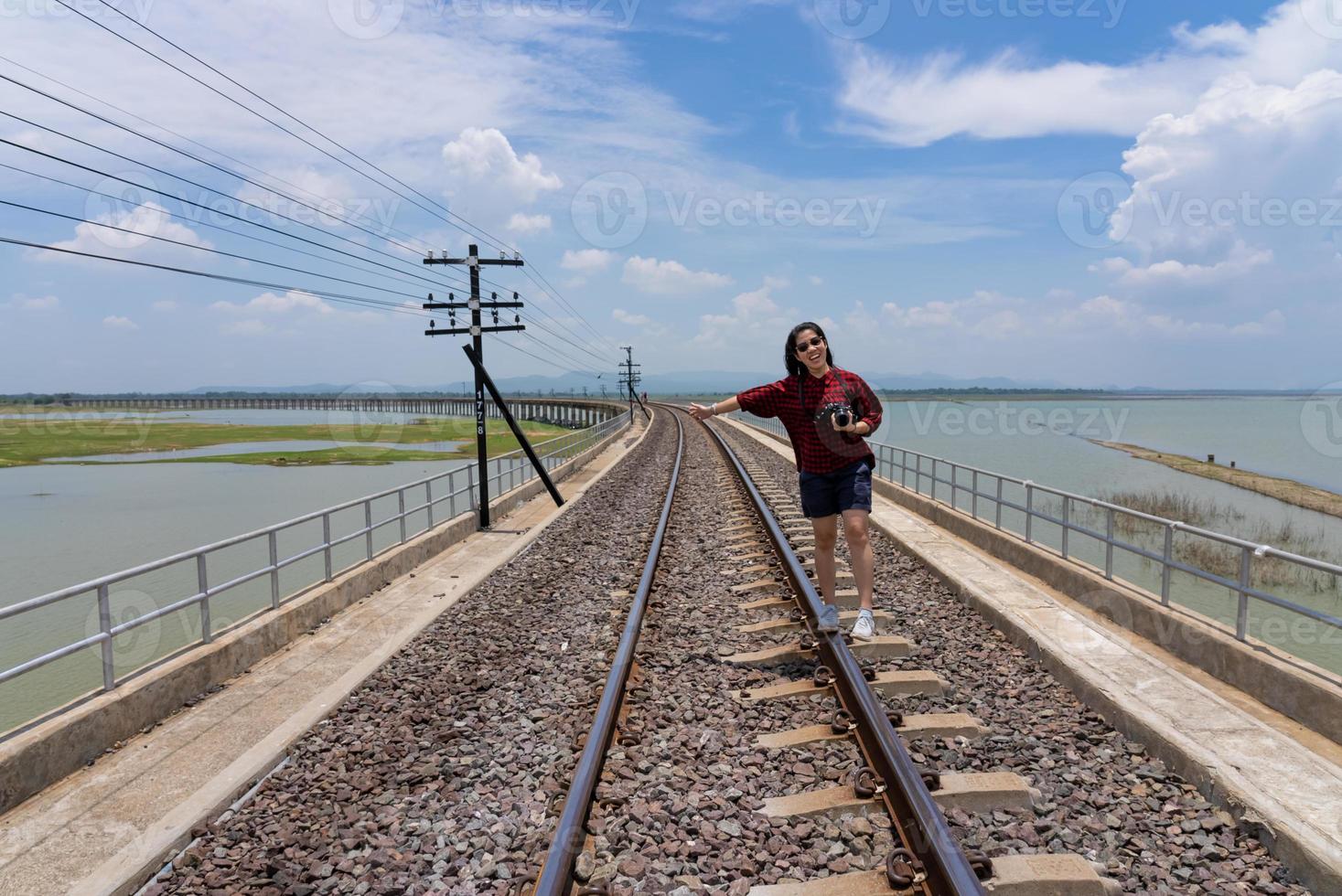 donna adulta che cammina sulla ferrovia durante il viaggio in vacanza estiva foto