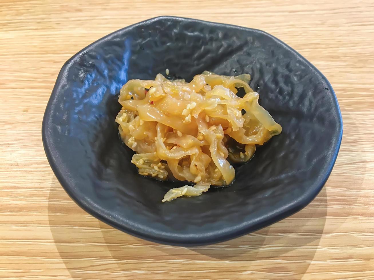 insalata di meduse in banda nera sul tavolo di legno. foto