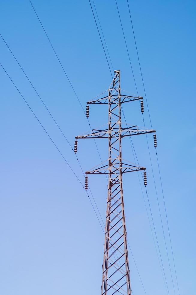 torre di trasmissione elettrica su sfondo verticale cielo blu. foto
