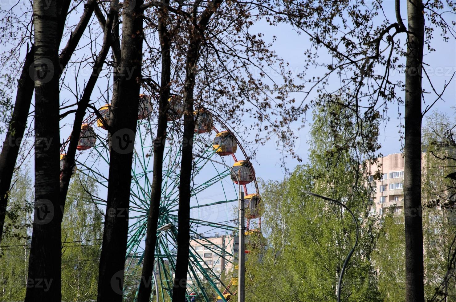 parco divertimenti, trampolini e una ruota panoramica. parco in città foto