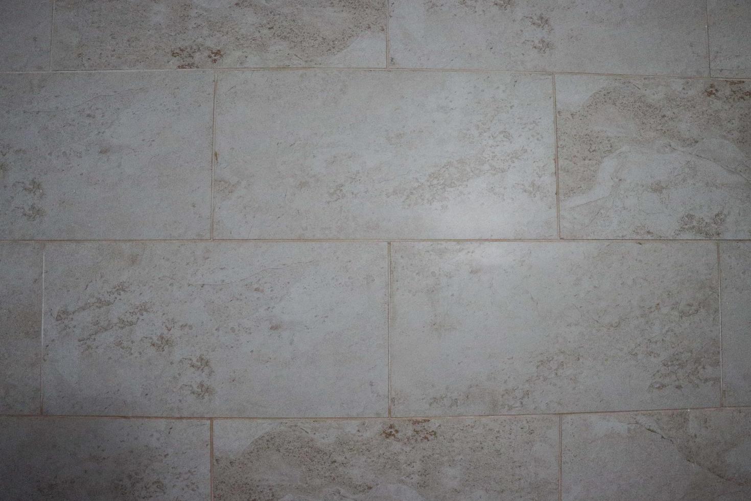 sfondo in marmo grigio con pietra di marmo italiano per piastrelle di ceramica. struttura di cemento incrinata su una piastrella. texture polverosa e macchiata su una foto ravvicinata del pavimento di piastrelle. effetto grunge tono grigio astratto.