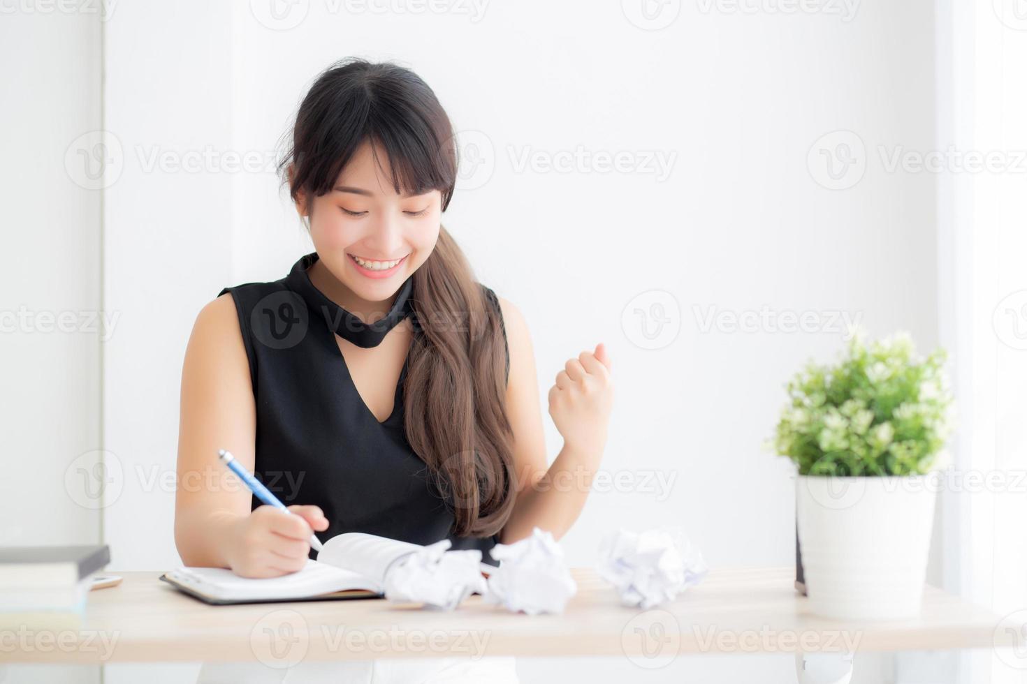 bella giovane scrittrice asiatica eccitata a scrivere su taccuino o diario con felice successo e felice, la ragazza asiatica di stile di vita è studente, lavoro di pianificazione femminile, istruzione e concetto di business. foto