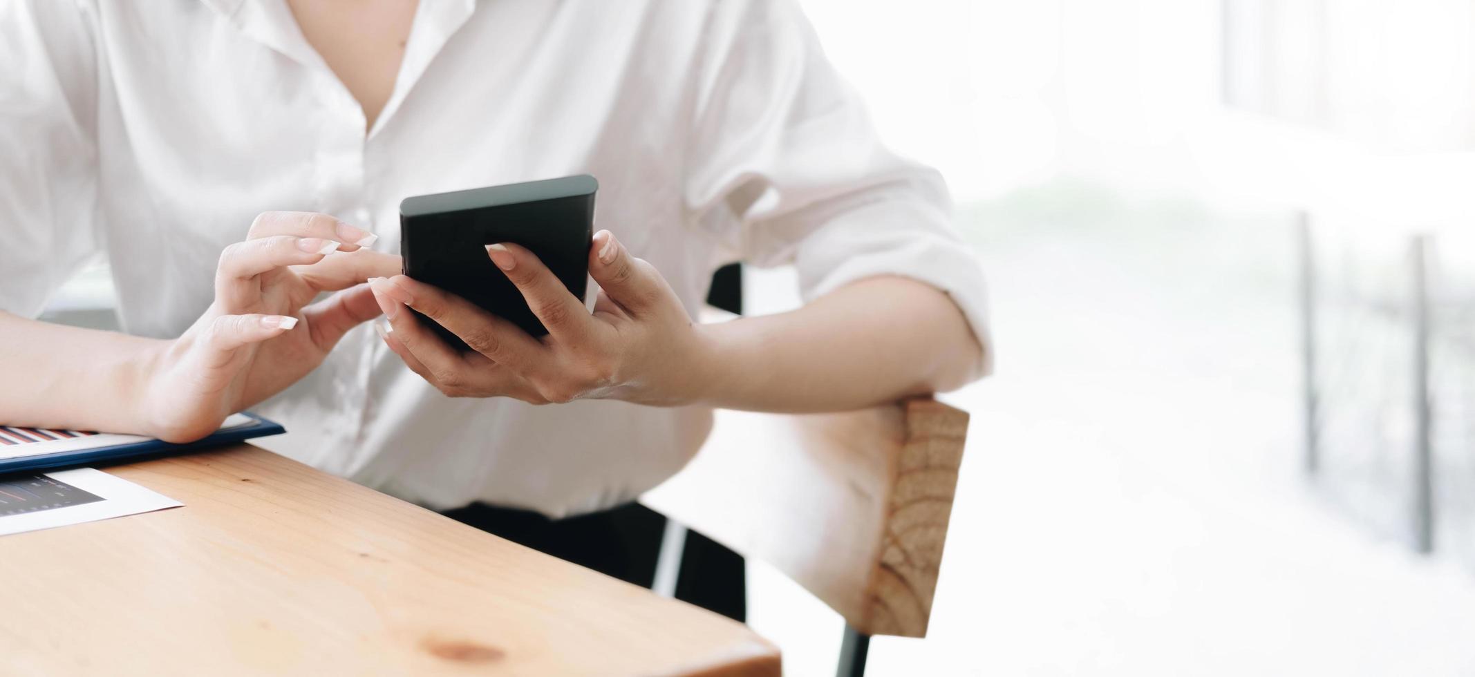 mano ravvicinata della donna che utilizza lo smartphone in ufficio. foto