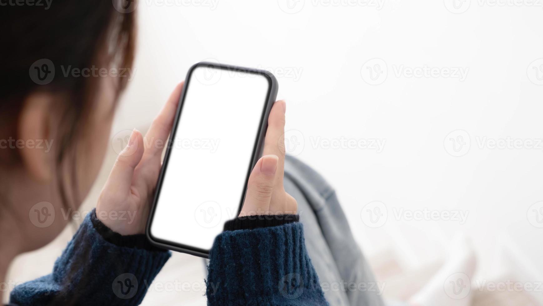 vista dall'alto delle mani della donna che tengono lo smartphone con lo schermo dello spazio di copia vuoto per il messaggio di testo o il contenuto informativo. foto