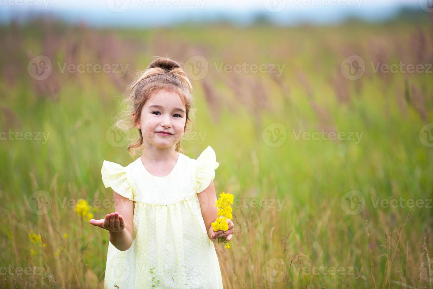 ritratto di una ragazza carina in campo con un fiore selvatico. infanzia, vacanze in campagna, libertà e spensieratezza. estate. giornata internazionale dei bambini. repellente per zanzare, nucleo cottage. copia spazio foto