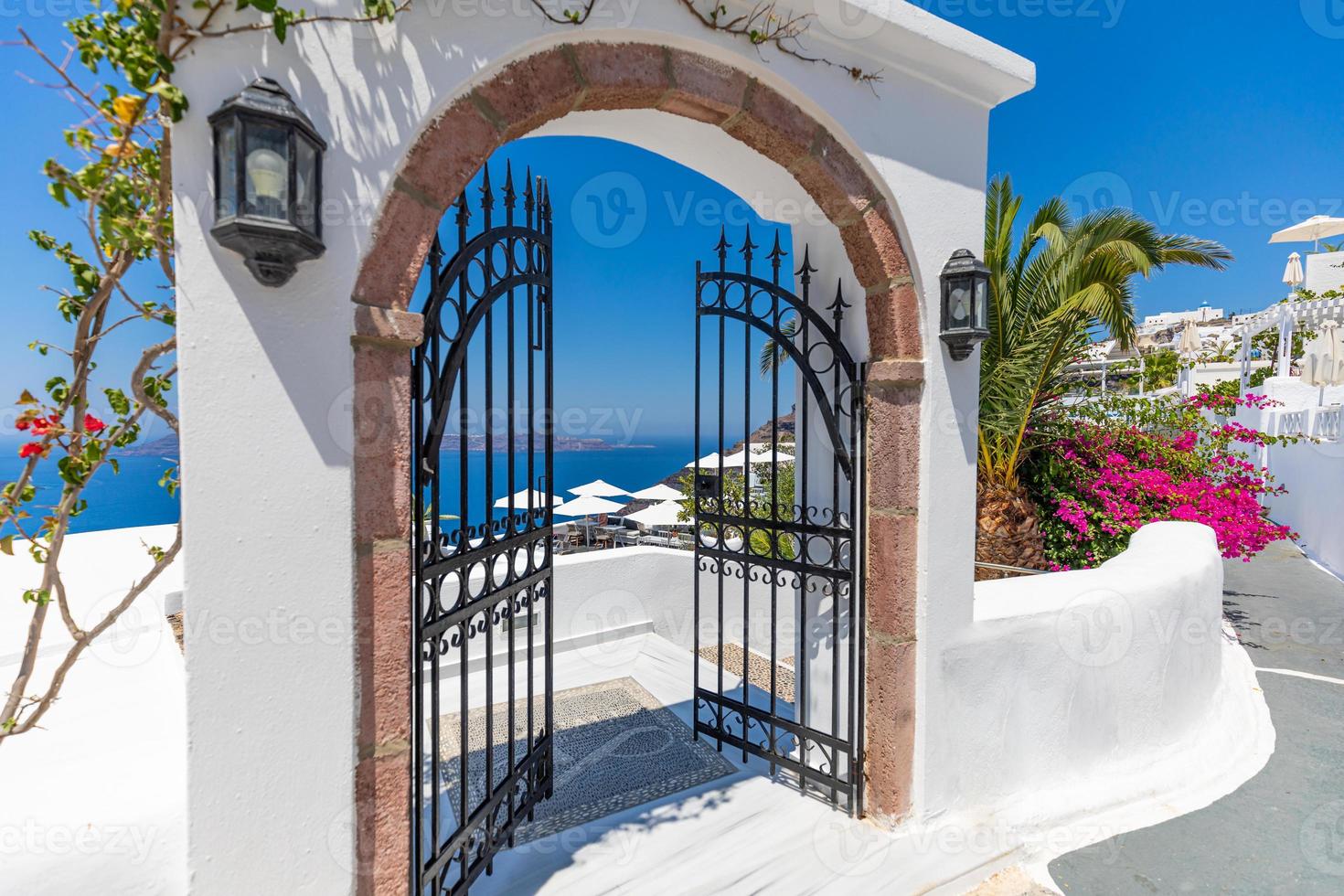 ingresso di una tipica architettura bianca delle Cicladi, casa con porta blu e pianta di bouganville rosa in fiore nell'isola di santorini in grecia. sfondo romantico idilliaco di ispirazione per le vacanze di viaggio foto