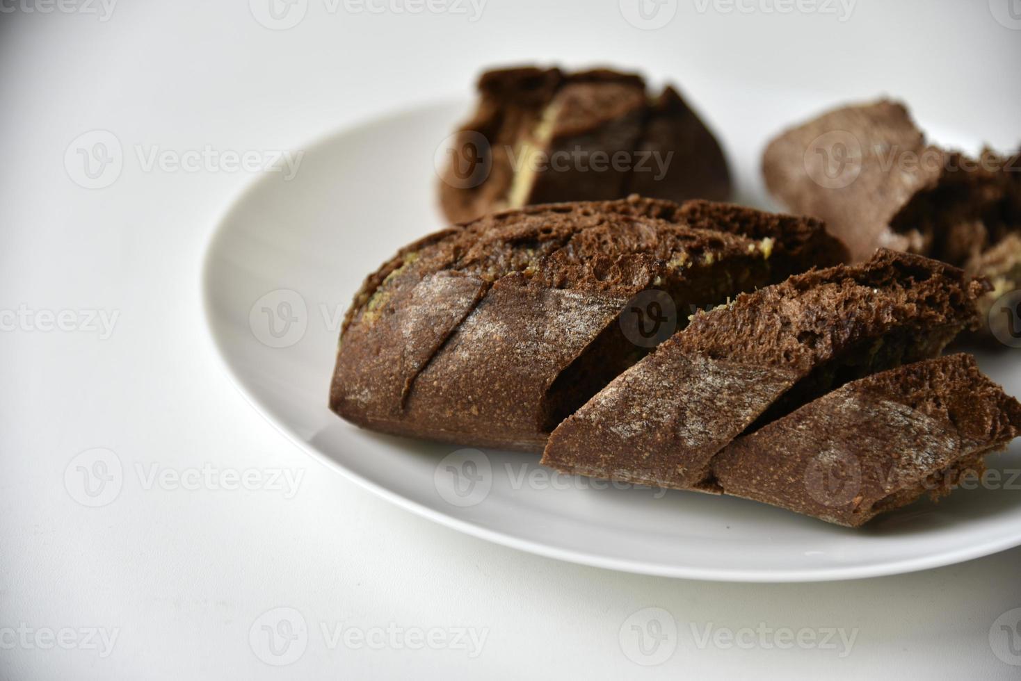 pezzi di pagnotta di pane nero su un piatto bianco foto