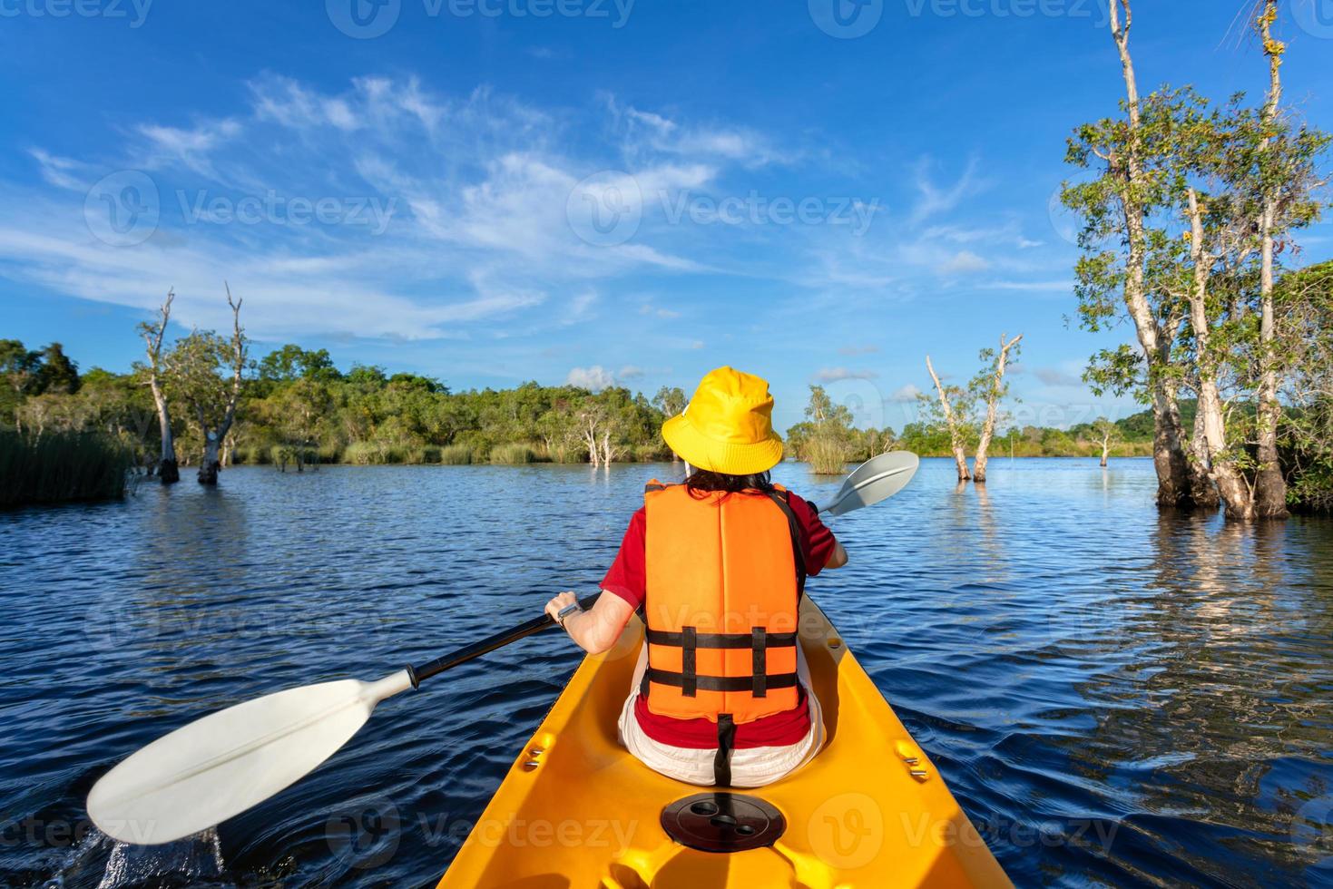 donna felice in kayak con barca in kayak nel lago nuture dietro il mare e la spiaggia prima del tramonto per rilassarsi e sport acquatici estremi foto