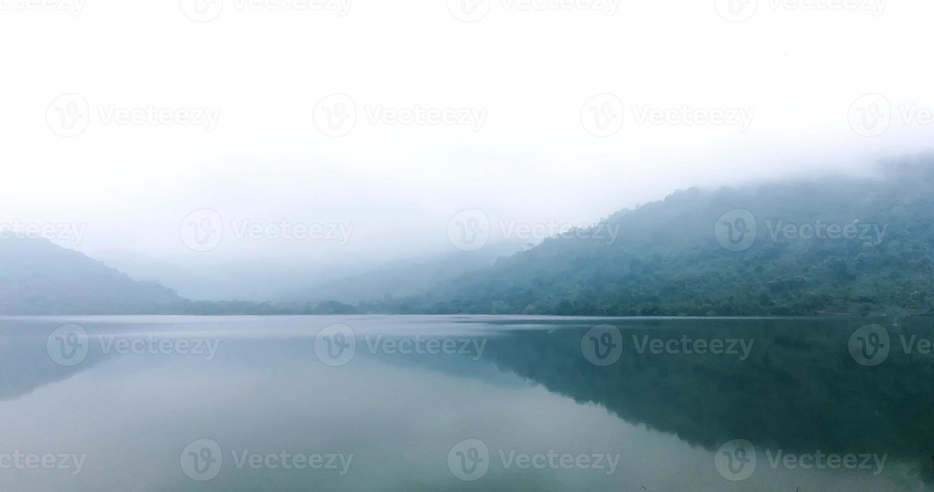 bellissimo paesaggio con vista sulle montagne e nebbia mattutina all'alba. incredibile sfondo naturale foto