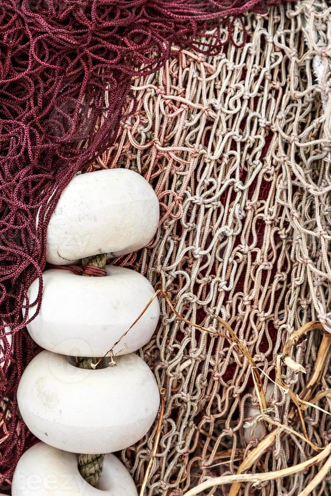rete da pesca bianca e rossa con tappi bianchi nel porto di santona, cantabria, spagna. immagine verticale. foto