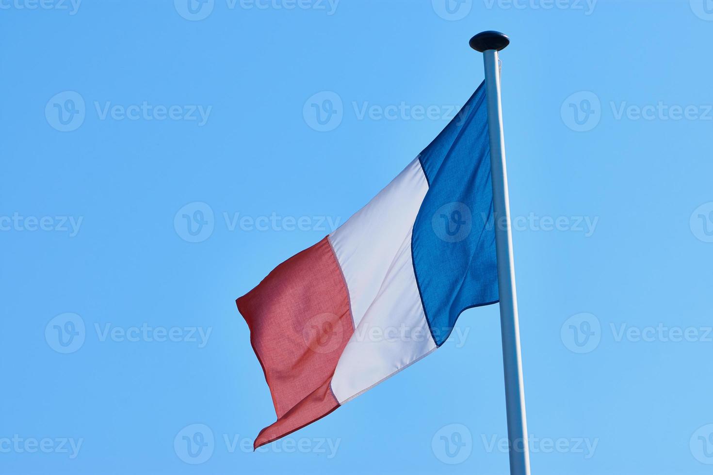 fotografia di una bandiera sventolante della Francia contro il cielo blu senza nuvole foto