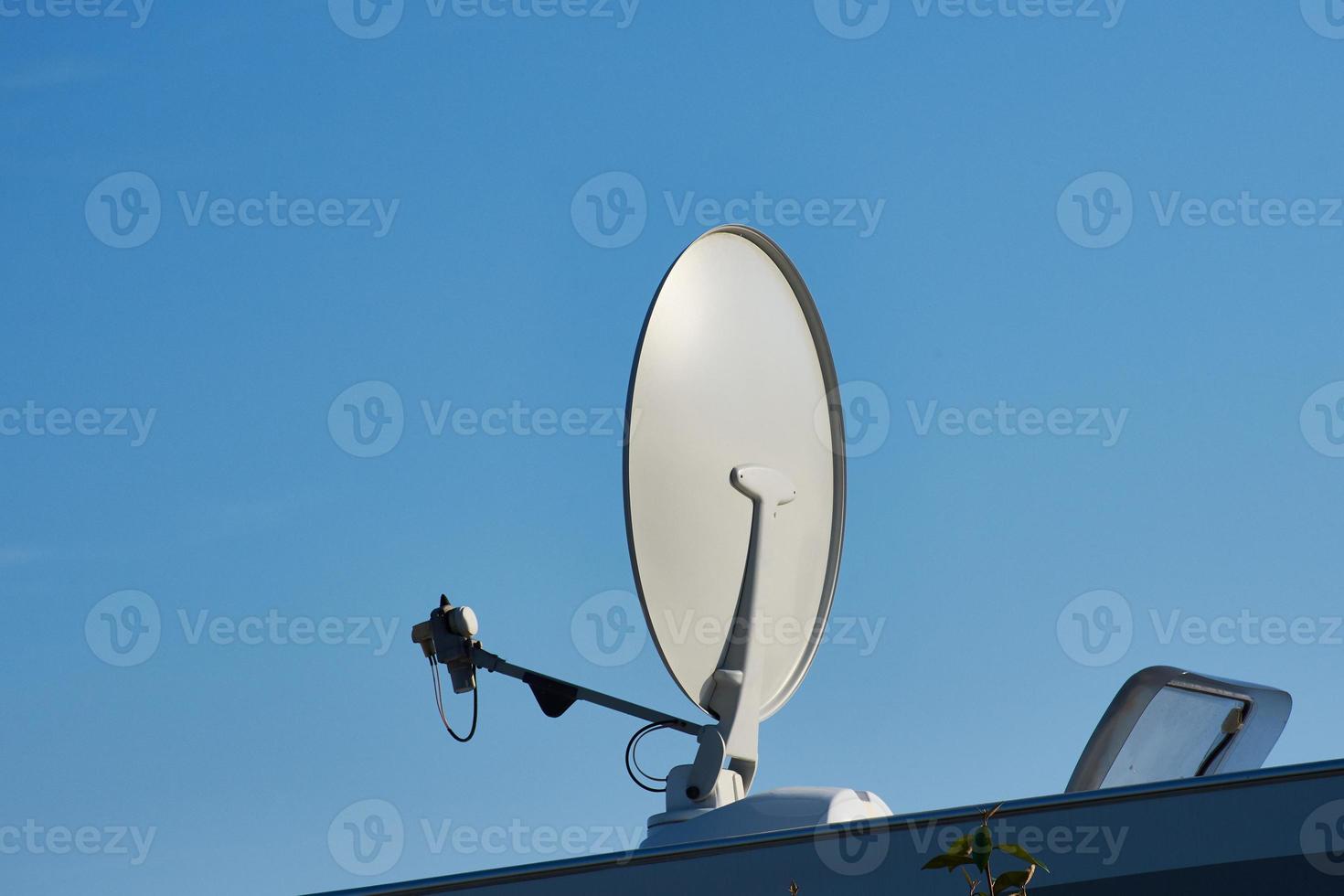 parabola satellitare bianca su una roulotte contro il cielo blu foto