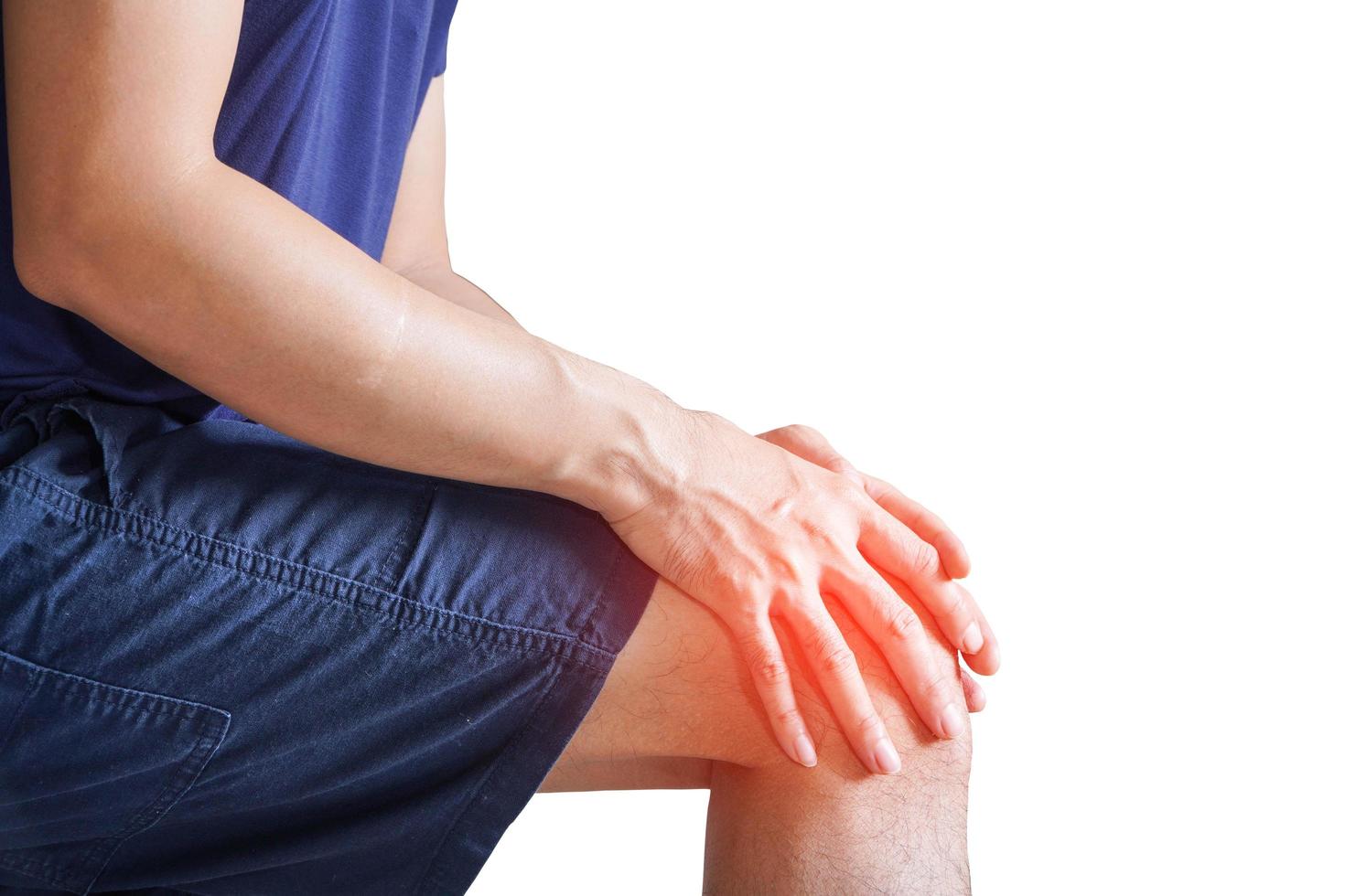 uomo con entrambi i palmi attorno alla rotula per mostrare dolore e lesioni sull'area del ginocchio, sfondo bianco, dolori articolari, artrite e tendini. foto