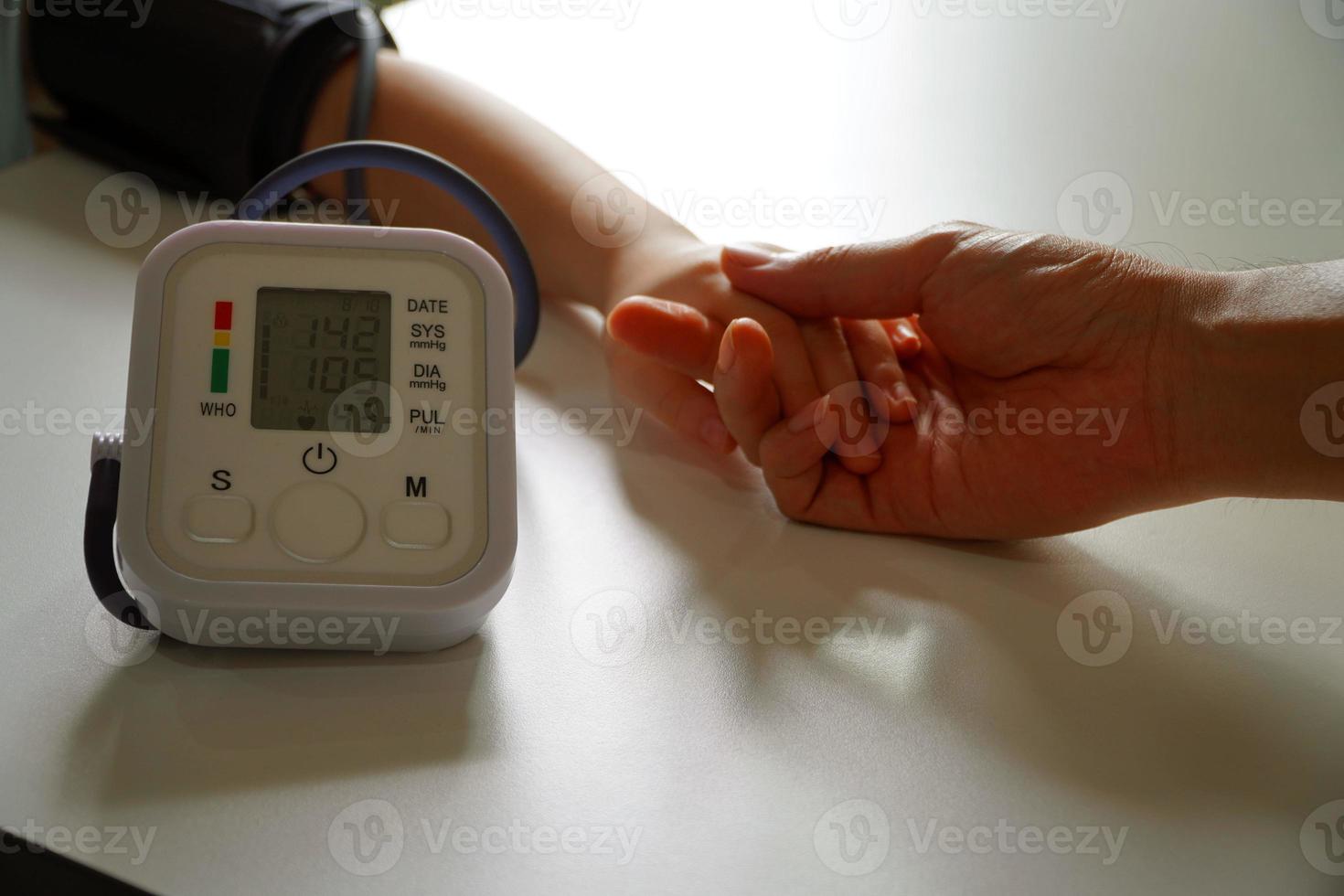 monitoraggio della pressione sanguigna dei pazienti che utilizzano il monitor della pressione sanguigna del braccio nella sala d'esame della clinica. foto