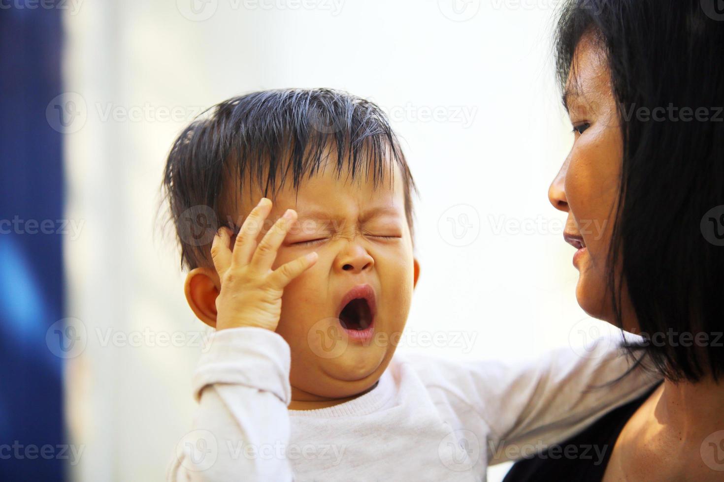 ritratto di bambino asiatico che sbadiglia con la madre. concetto di festa della mamma di stile di vita della donna. foto
