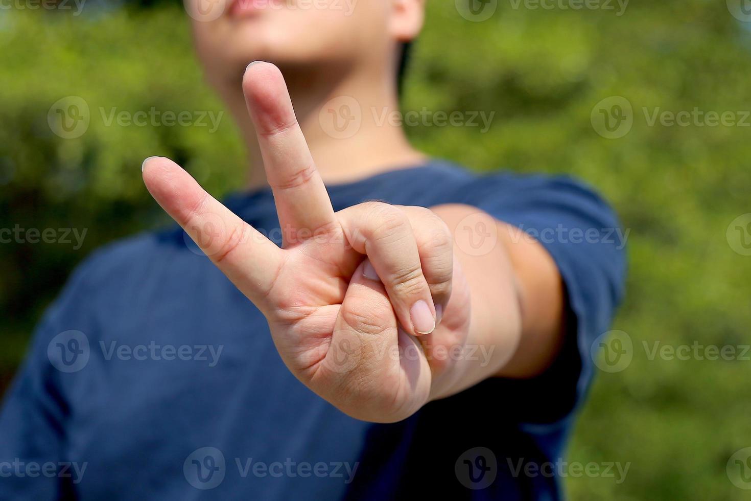 l'uomo mostra due dita come segno av. simbolo della vittoria. simbolo di pace. foto
