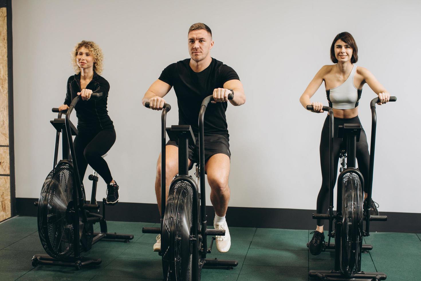 giovane uomo e donna che usano la bici ad aria per l'allenamento cardio presso la palestra di cross training foto