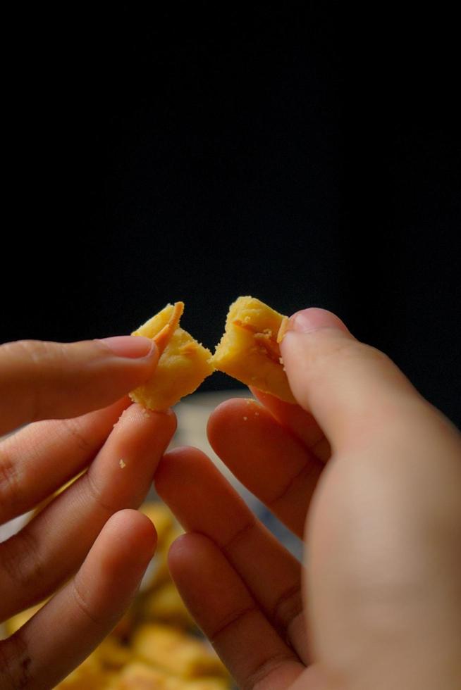 biscotti kaastengel croccanti. biscotti indonesiani di influenza olandese, tipicamente serviti durante l'hari raya eid fitri. immagine di messa a fuoco selettiva su sfondo nero foto