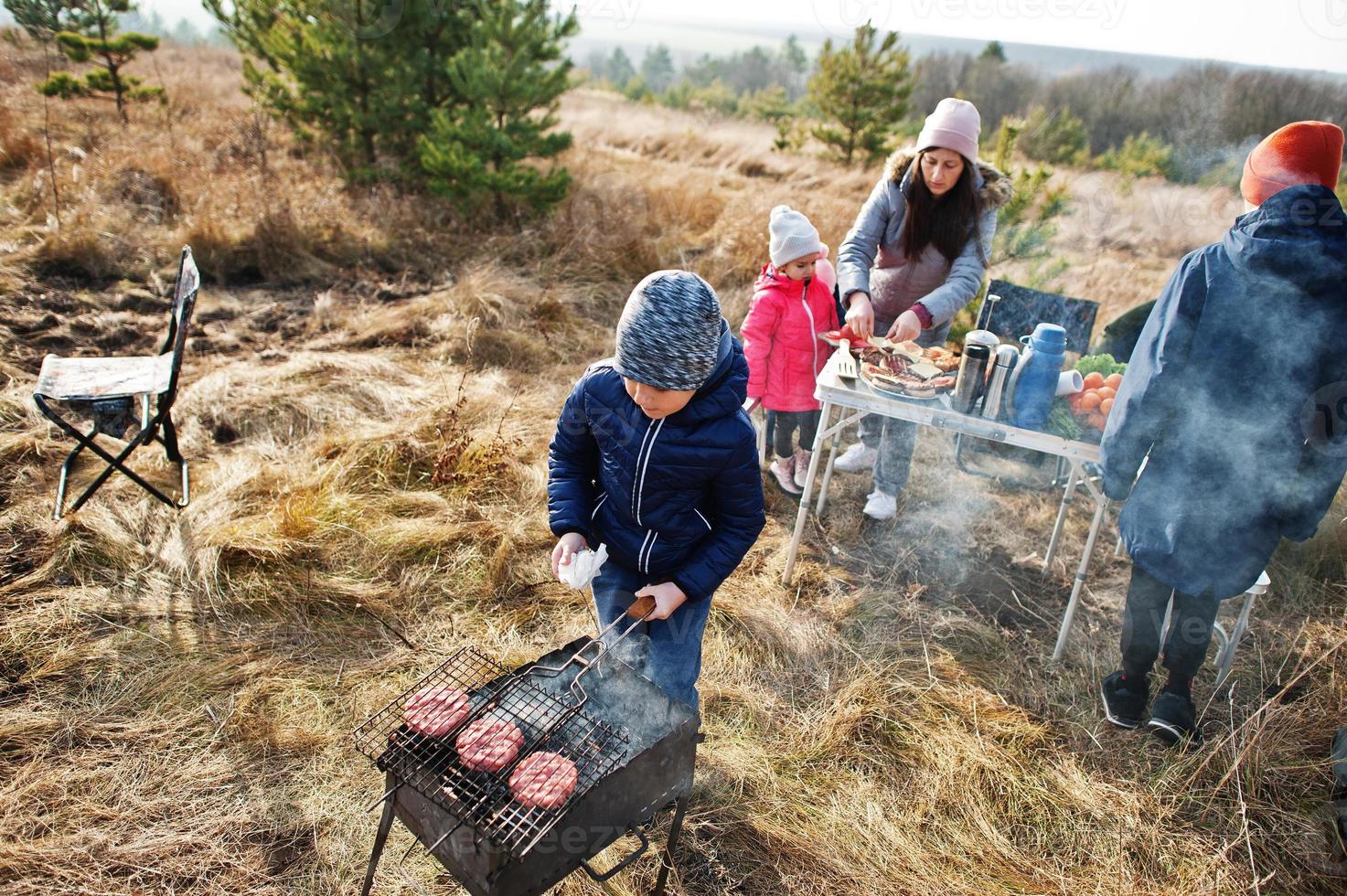 famiglia al barbecue su una terrazza nella pineta. giornata barbecue con griglia. foto