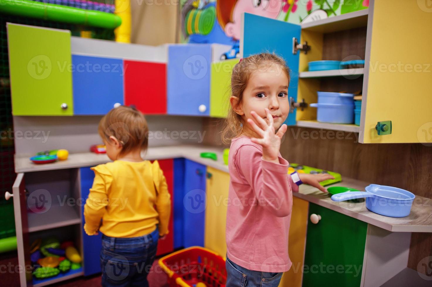 sorelle carine che giocano nel centro giochi al coperto. stanza dei giochi dell'asilo o della scuola materna. nella cucina dei bambini. foto