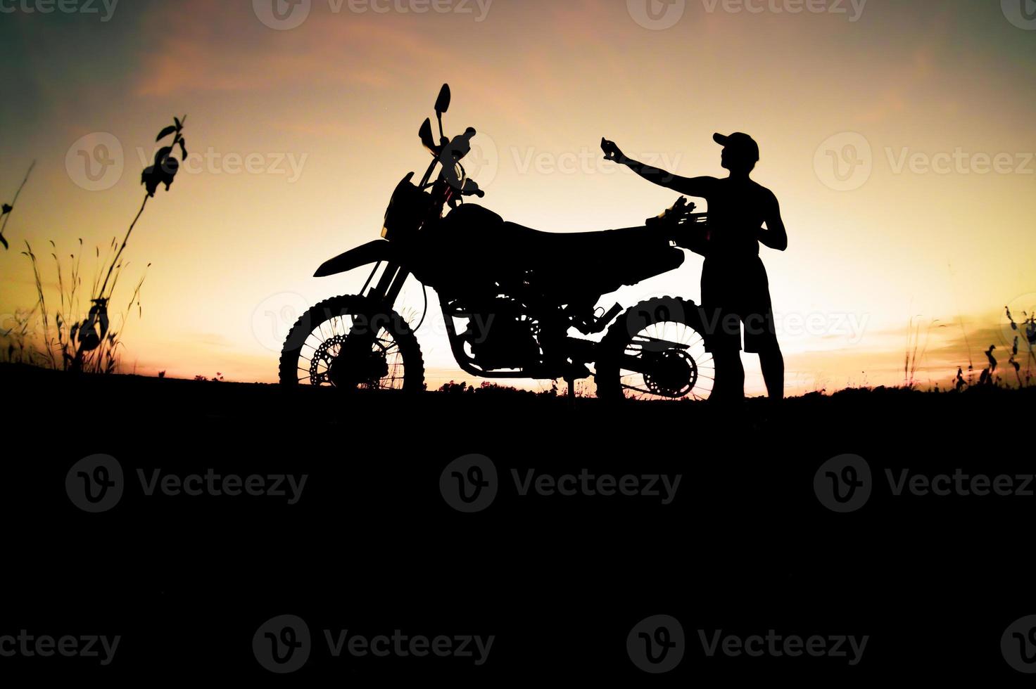 sagome maschili e moto da cross da turismo. parco per rilassarsi in montagna la sera. concetto di viaggio avventura e tempo libero foto