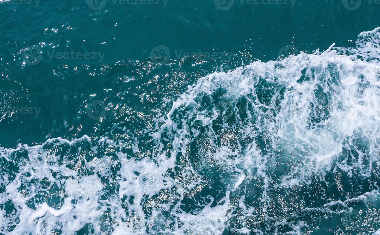 bellissime onde del mare con schiuma di colore blu e turchese. acqua di mare blu astratta con onda bianca. onde bianche e blu della strada della nave sull'oceano di mare dell'acqua. foto