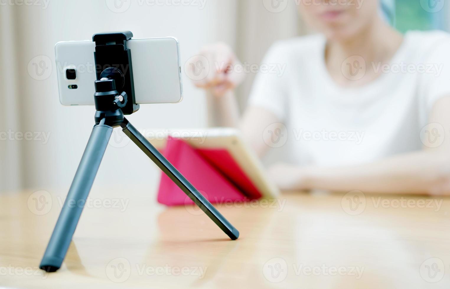vlogger donna che guarda utilizzando il computer iPad e filma in video la sua vita foto