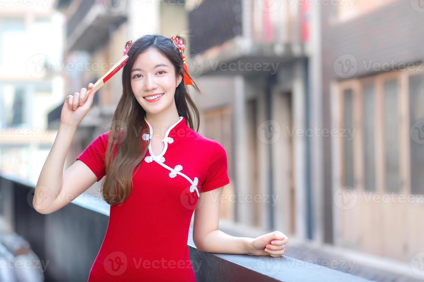 bella donna asiatica in abito rosso si trova tra il centro storico nel tema del capodanno cinese. foto
