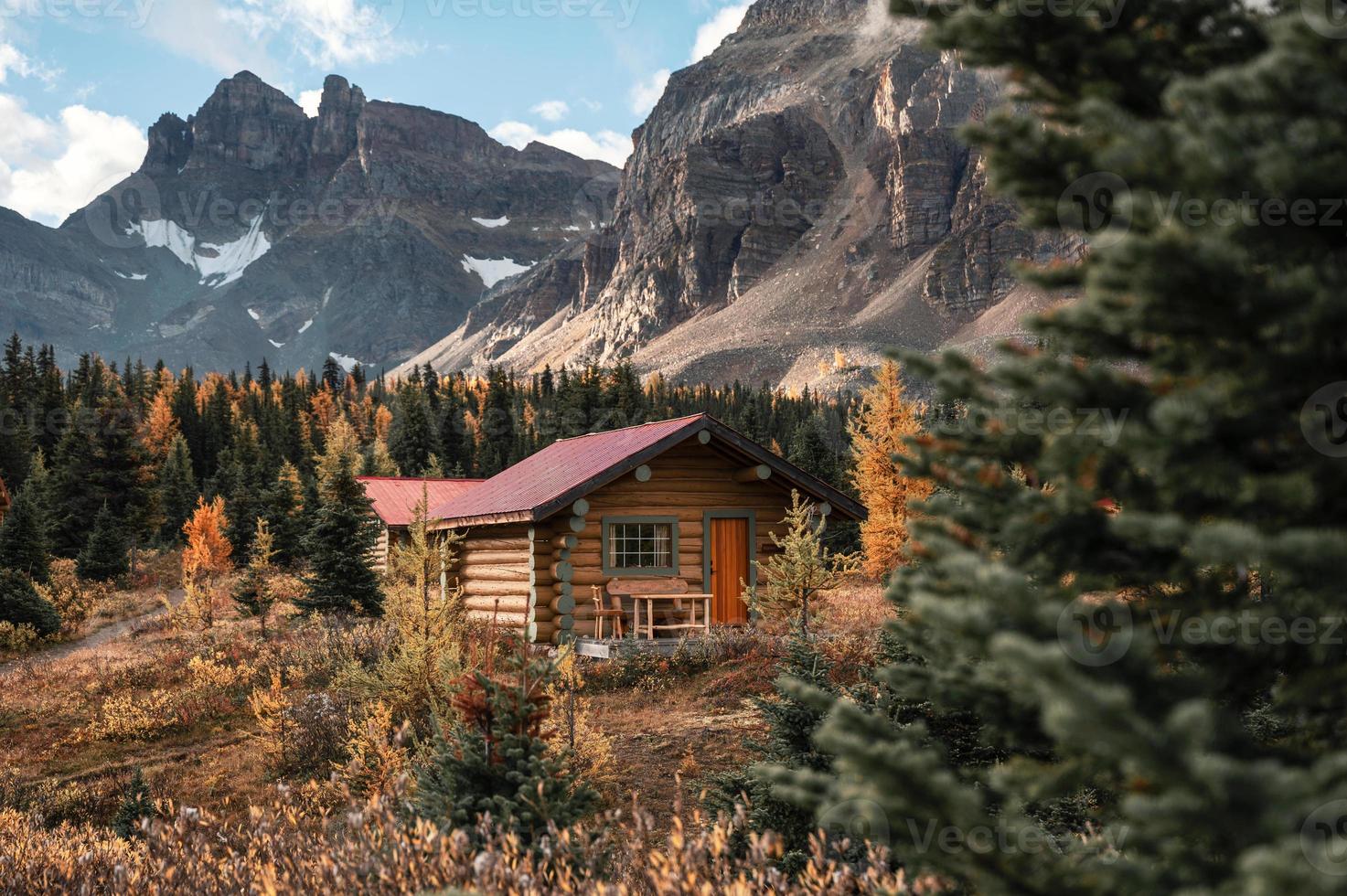 capanne di legno con montagne rocciose nella foresta autunnale del parco provinciale di assiniboine foto