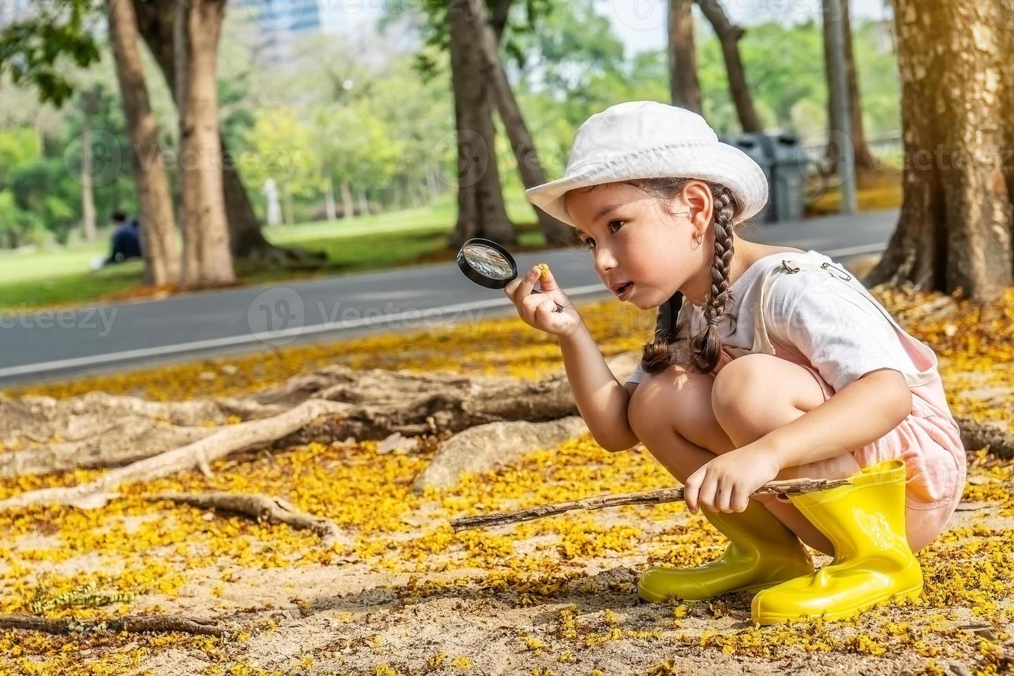 immagine della ragazza carina che esplora la natura con la lente d'ingrandimento all'aperto, bambino che gioca nella foresta con la lente d'ingrandimento. bambino curioso che cerca con la lente d'ingrandimento sull'erba nel parco foto