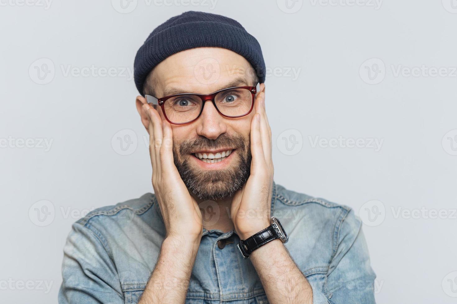 il ritratto di un giovane attraente con barba folta e baffi guarda con espressione felice, ha denti bianchi perfetti, posa in studio contro lo spazio vuoto della copia. persone ed emozioni positive foto