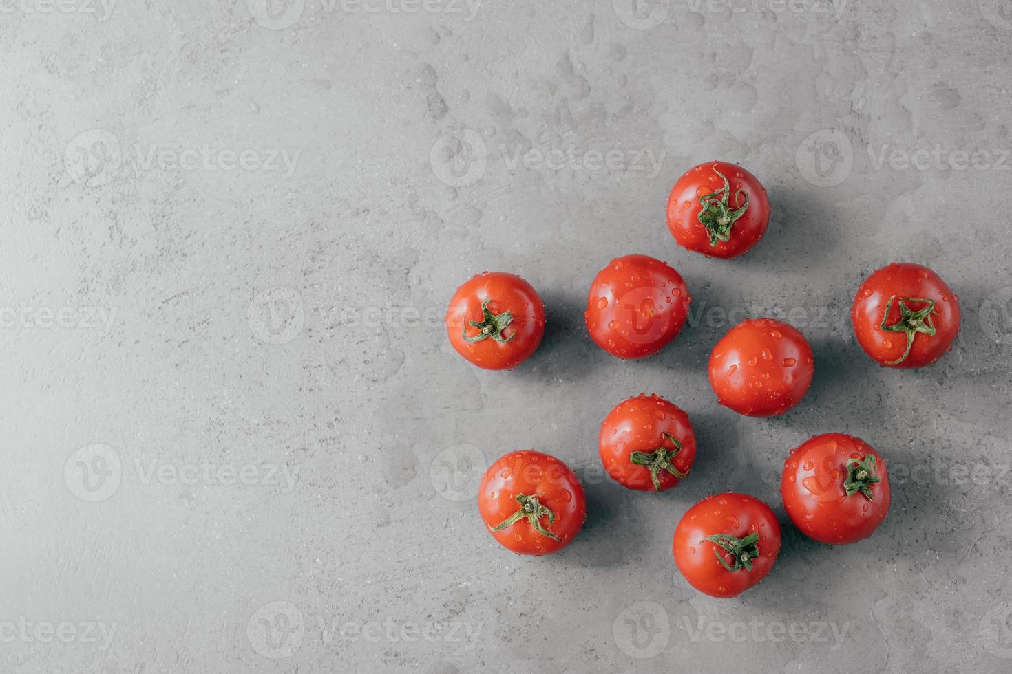 pomodori rossi freschi con gocce d'acqua isolate su sfondo grigio con spazio di copia. alimento biologico naturale contenente vitamine foto