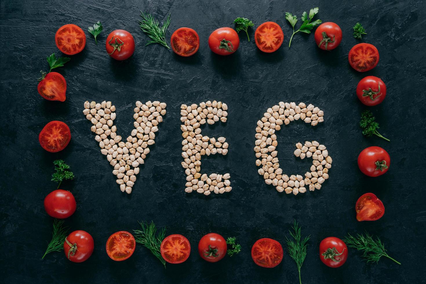 foto di cornice di pomodori e lettere di ceci che significano veg. semi organici all'interno del telaio vegetale isolato su sfondo scuro. vegetarianismo