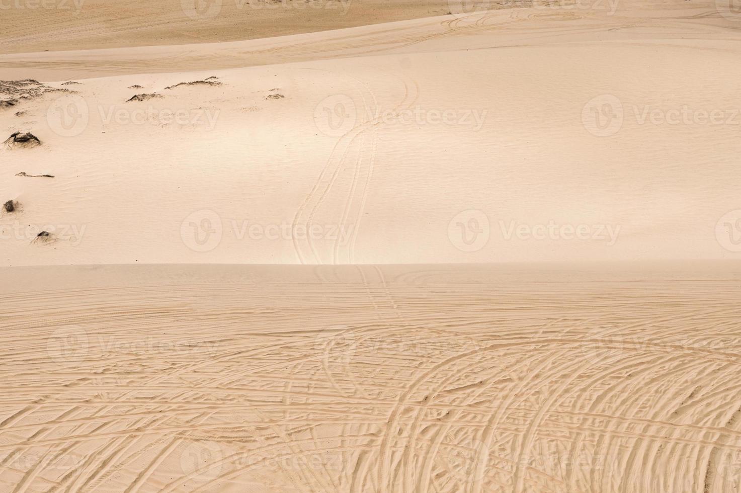 paesaggio di dune di sabbia con auto solco nel deserto bianco foto