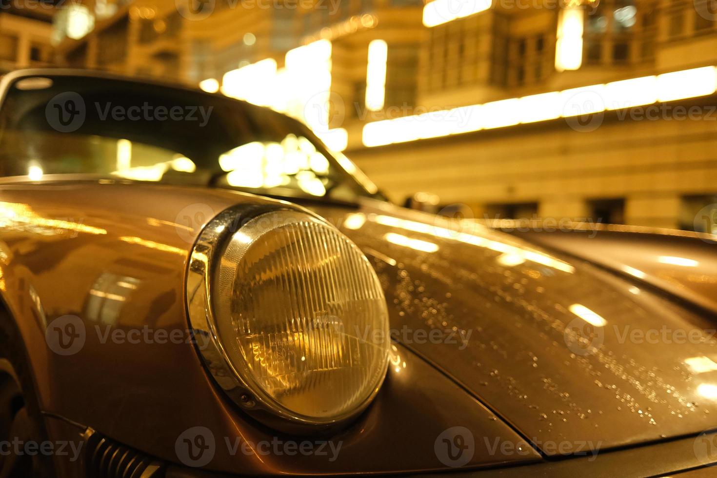 primo piano di auto d'epoca nel mezzo delle città di notte foto