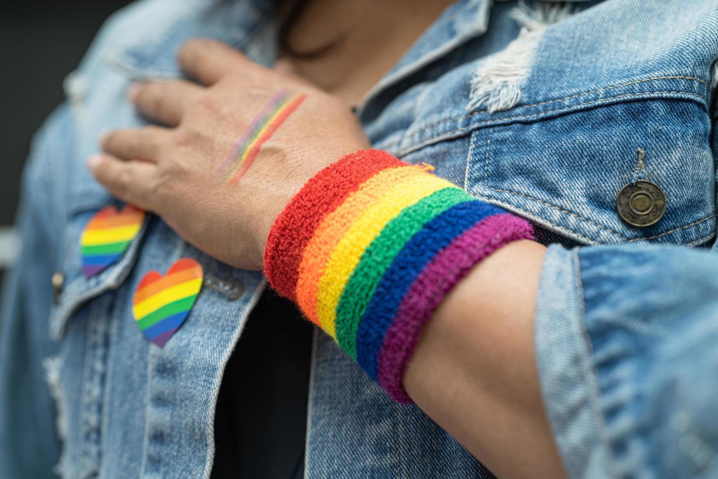 signora asiatica che indossa braccialetti con bandiera arcobaleno, simbolo del mese dell'orgoglio lgbt celebra l'annuale a giugno sociale di gay, lesbiche, bisessuali, transgender, diritti umani. foto