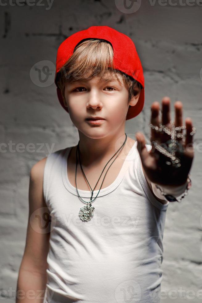 ritratto di giovane ragazzo hip hop fresco con cappello rosso e pantaloni rossi e camicia bianca nel soppalco foto