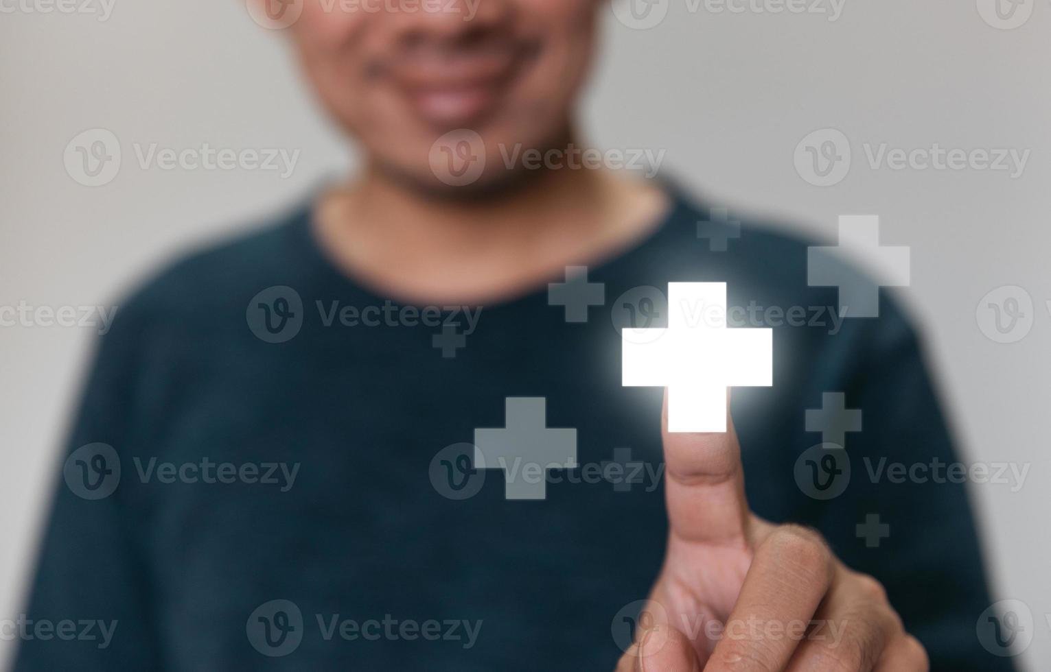 bell'uomo che tocca l'icona del segno più significa offrire una cosa positiva. foto