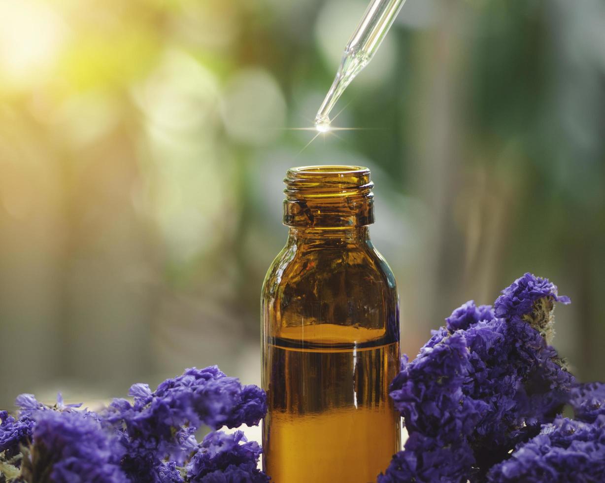 olio essenziale che cade dal contagocce di vetro nella bottiglia marrone bio medicina alternativa organica. concetto di bellezza e spa. foto