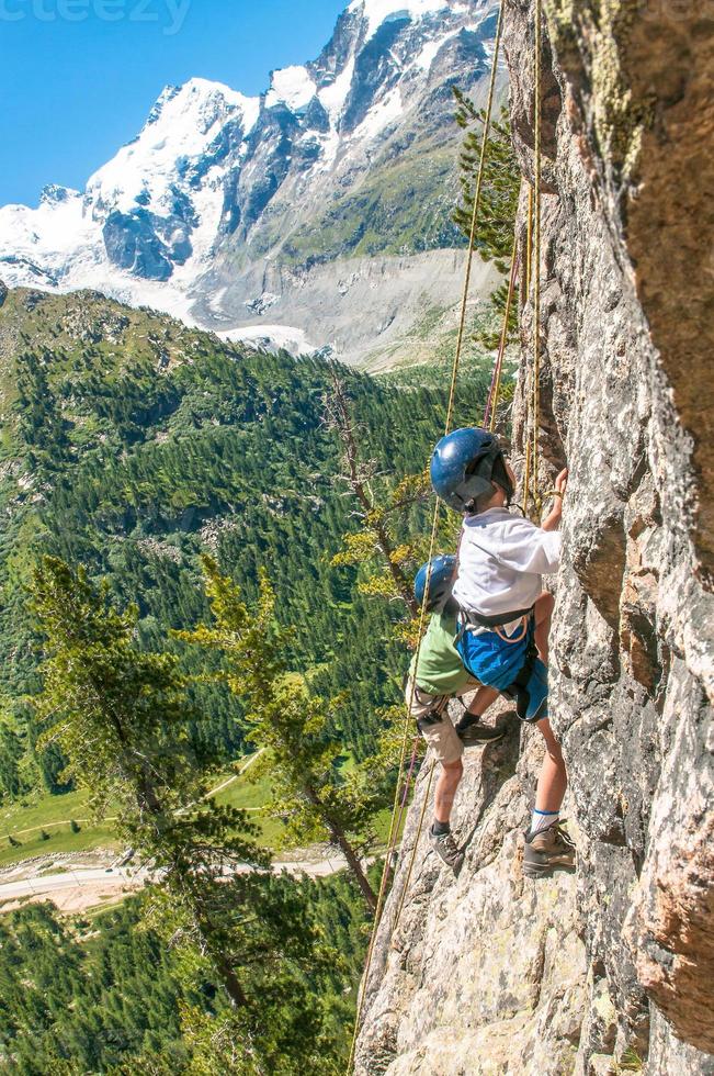 bambini che si arrampicano in alta montagna foto