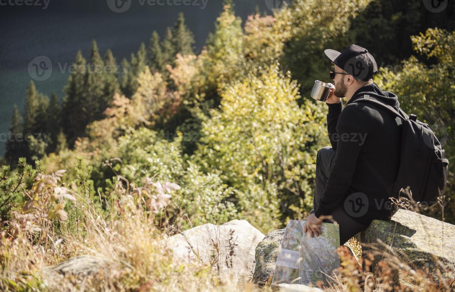 turista uomo rilassante sulla cima di una collina foto