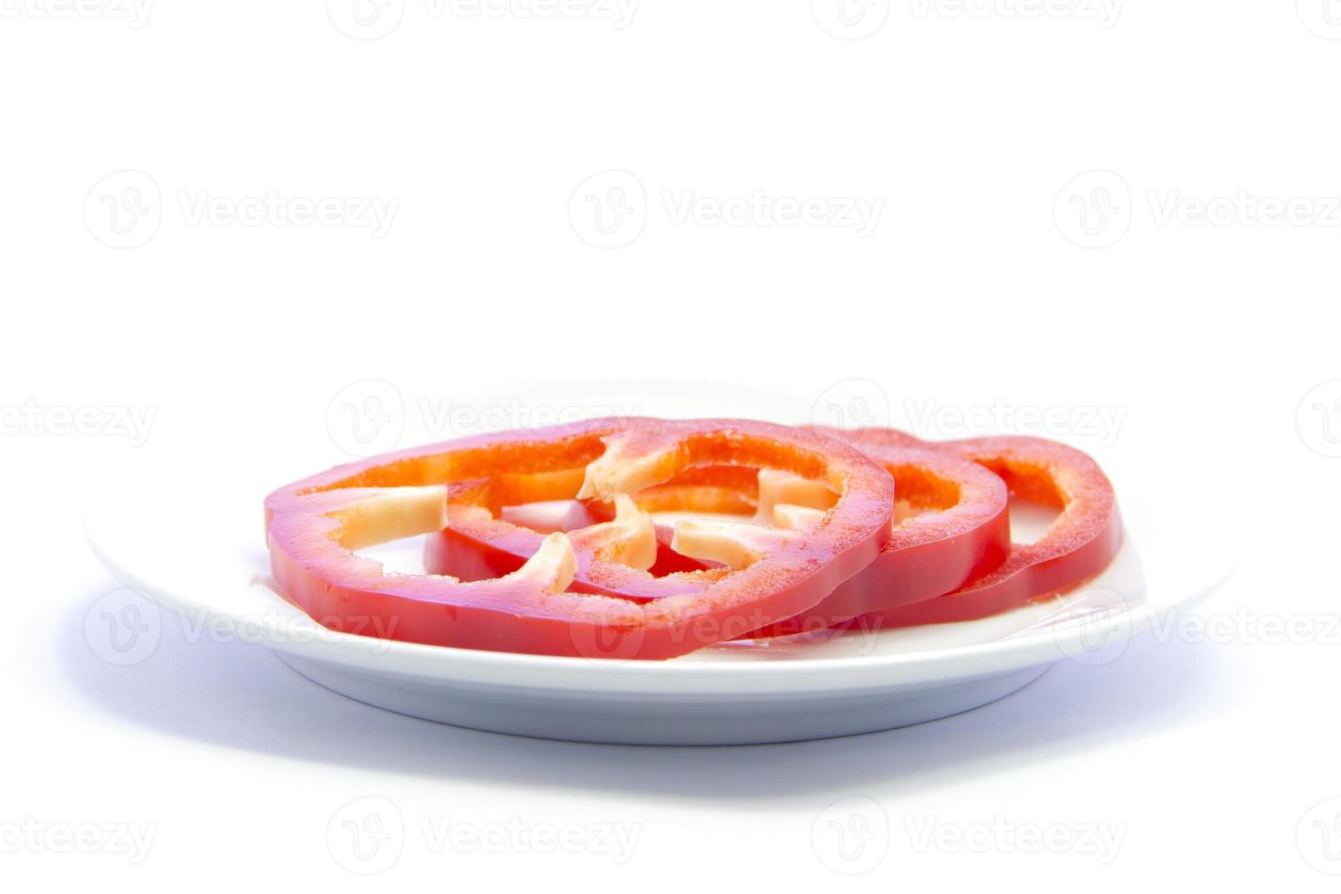 peperoncino rosso campana affettato sul piatto bianco foto