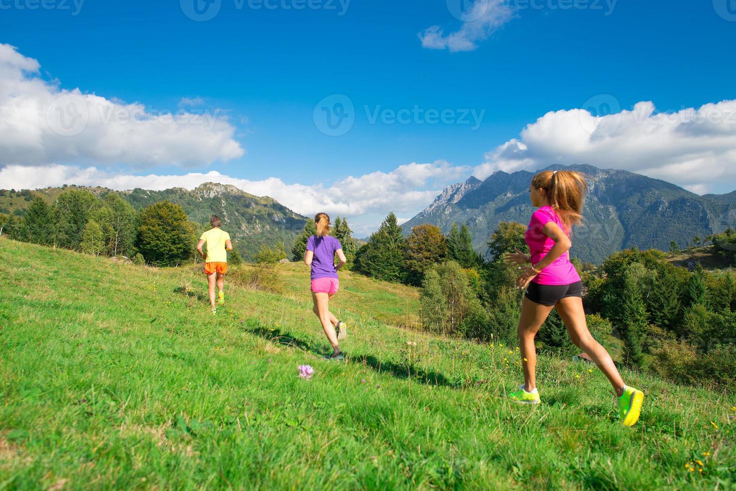 l'allenatore corre con le sue ragazze da corsa in montagna foto