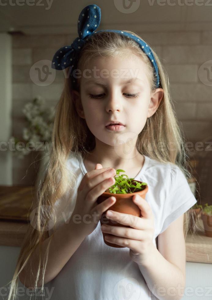 bambina che tiene un vaso di piantine foto