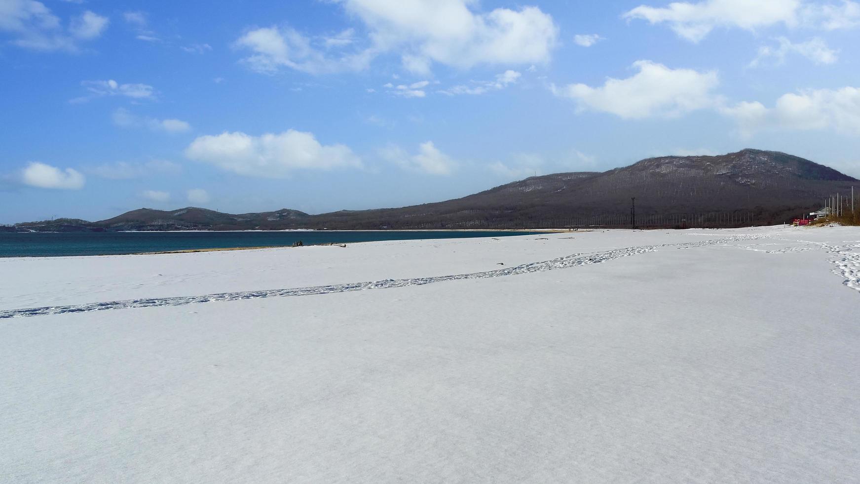 vista sul mare che domina la spiaggia nella neve foto