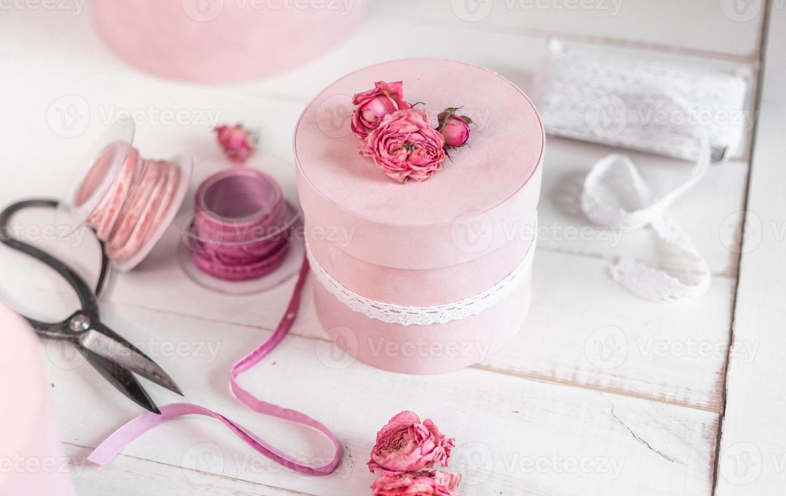 bella confezione regalo rotonda rosa è decorata con rose strette. concetto di imballaggio romantico foto